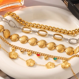 Detail of 18K gold plated stainless steel bracelets with heart and flower charms