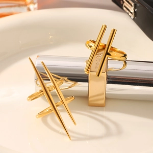 Detailed close-up of 18K gold plated stainless steel geometric rings on silver pedestals