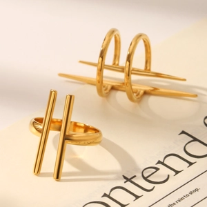 Detail of 18K gold plated geometric rings on paper with script, minimalist jewelry style