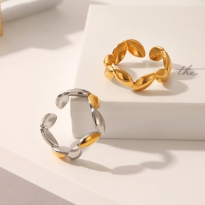 Details minimalistischer geometrischer Edelstahlringe in Gold und Silber auf weißem Block