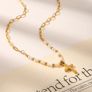 Golden paperclip chain necklace with white pearls and textured cross pendant