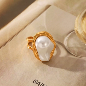 Macro detail of a baroque pearl ring with irregular texture on golden double bands