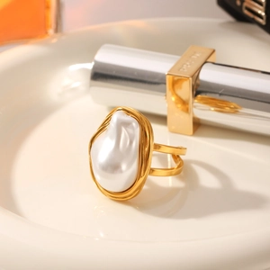 Elegant gold baroque pearl ring with a fluid geometric design on a stylish display