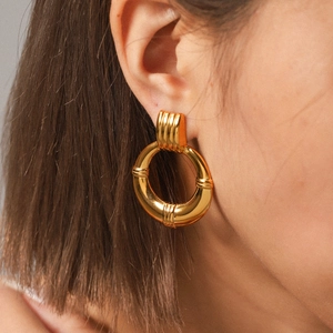 Close-up of 18K gold-plated hoop earrings with retro bamboo textures on a female model