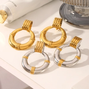 Detail view of retro 18K gold hoop earrings with tiered texture clasps on white base