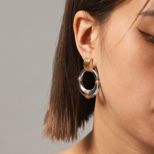 Chic 18K gold and silver two-tone stainless steel hoop earrings worn by a model