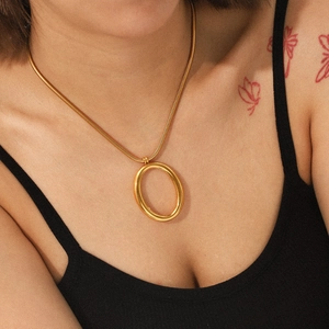 Gold-plated stainless steel snake chain necklace with oval pendant on female model