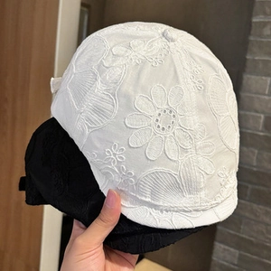 Detail shot of black and white baseball caps with 3D floral lace embroidery textures