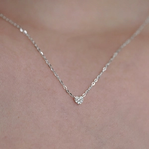 Detailed close-up of a tiny 925 sterling silver heart pendant with pavé set cubic zirconia