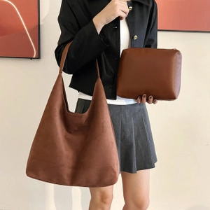 Detail showing a large brown matte tote bag with a matching zipper pouch for organization