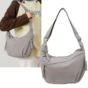 Detail of grey crescent tote bag with thick woven rope zipper pull and adjustable strap