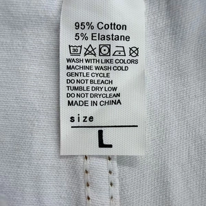 Macro dettaglio dell'etichetta di lavaggio con 95% cotone e specifiche della taglia L