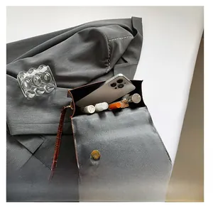 Internal view of minimalist brown crocodile texture handbag showing phone and lipstick storage