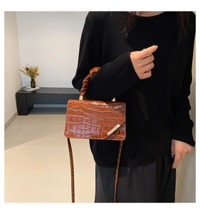 Detail of brown crocodile pattern shoulder bag with unique pleated ruched handle