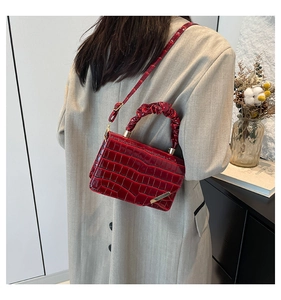 Red crocodile texture bag with scrunchie handle on model in grey blazer