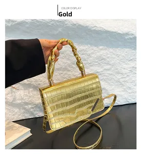 Detail of gold crocodile texture leather bag with pleated handle and metallic finish