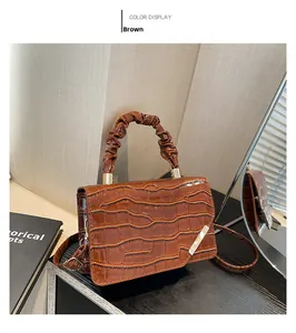 Brown crocodile pattern faux leather handbag featuring gathered handle and metal detail