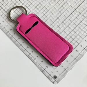 Detail showing the size and rose pink neoprene lipstick holder with metal keyring