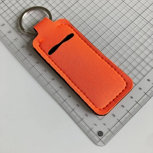 Detail of orange neoprene keychain lipstick holder with black stitching and metal ring