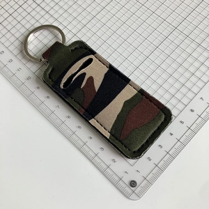 Detail showing camouflage canvas keychain lipstick pouch on a white measurement grid