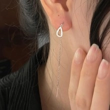 Detail of silver drop earrings with rhinestones showing elegant fit and long tassel chain