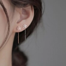 Detail of silver floral long tassel threader earrings with cubic zirconia on model