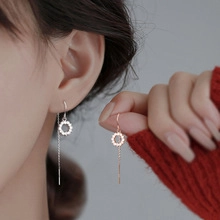 Detail view of long tassel earrings with sparkling rhinestone circle and silver chain