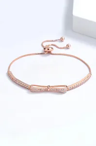 Detail of rose gold bow bracelet with zircon stones and adjustable slider bead clasp