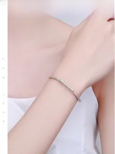 Close-up of model wearing silver bow bracelet with micro-pave cubic zirconia accents