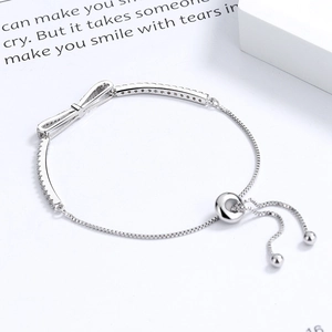 Silver bow bracelet with sparkling zircons and adjustable sliding clasp for women