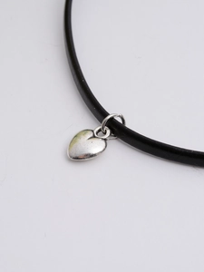 Close-up of minimalist black cord necklace with a polished silver heart pendant for women