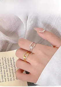 Detail view of gold and silver knot rings worn on finger with minimalist aesthetic