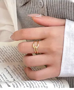 Detail of a minimalist gold knot ring on a hand over a magazine for an elegant lifestyle look
