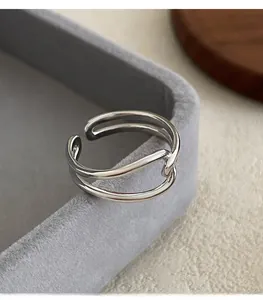 Detail of a minimalist 925 silver knot ring on a textured jewelry display tray