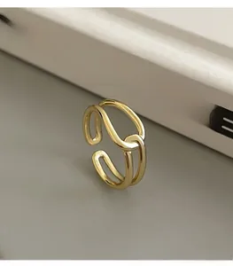 Macro shot of gold knotted wave ring on an open book featuring a minimalist design