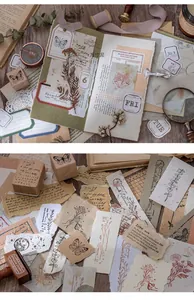 Close-up of vintage scrapbook paper set with butterfly and botanical patterns on wood