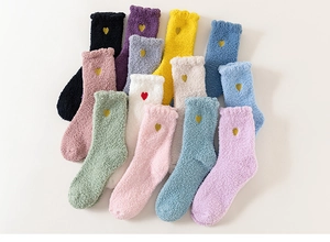 Dettaglio calze in pile corallo multicolori con piccoli cuori ricamati e soffice tessuto