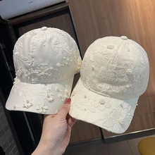 Detail of white baseball cap with delicate floral embroidery and elegant pearl accents