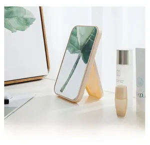 Macro shot of rectangular folding vanity mirror with cream frame on a desk
