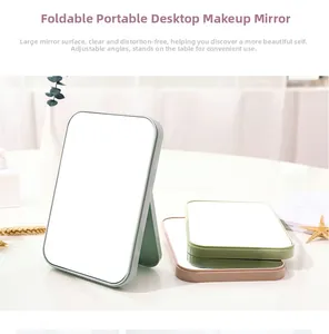 Foldable desktop makeup mirror with adjustable angles in pastel pink and green shades