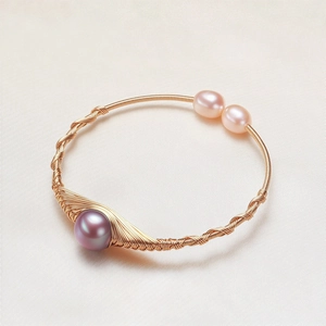 Detail of handmade wire-wrapped bracelet featuring lavender pearls on silk background