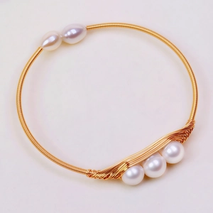 Detailed macro view of 14K gold plated wire wrapped bracelet with freshwater pearls