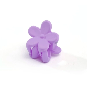 Close-up of small purple plum flower hair clip with a matte finish plastic texture