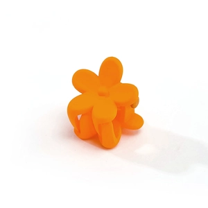Detailed macro view of an orange matte plastic flower hair claw clip for girls