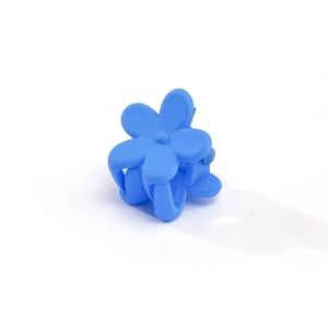 Macro detail of a bright Klein blue matte flower hair claw clip for girls