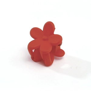 Detail shot of mini bright orange flower hair claw clip with matte frosted finish