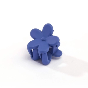 Detailed macro view of small matte fog blue flower hair claw clip for girls