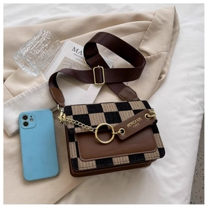 Close-up of beige checkerboard crossbody bag with brown leather trim and gold ring detail
