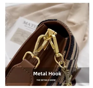 Detailed close-up of premium golden hardware hook and metal chain on a tweed handbag
