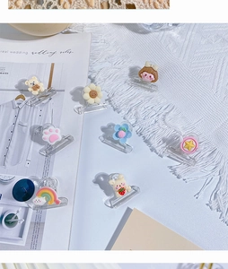 Detailed view of eight assorted cartoon acrylic clips including bear and rainbow designs
